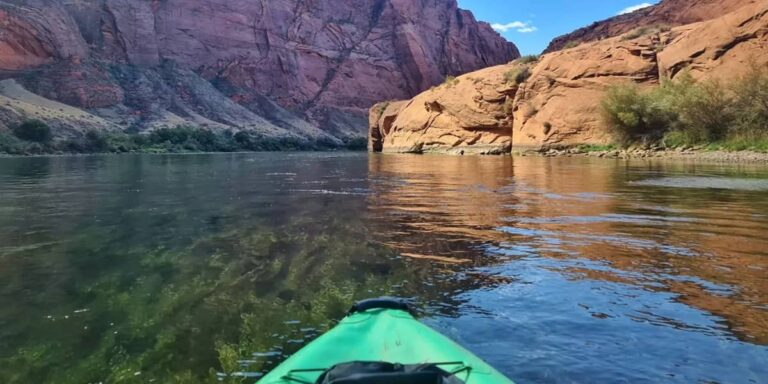 Kayaker paddling through canyon on calm river, one of the best places to kayak in the US for scenic views and peaceful water access.